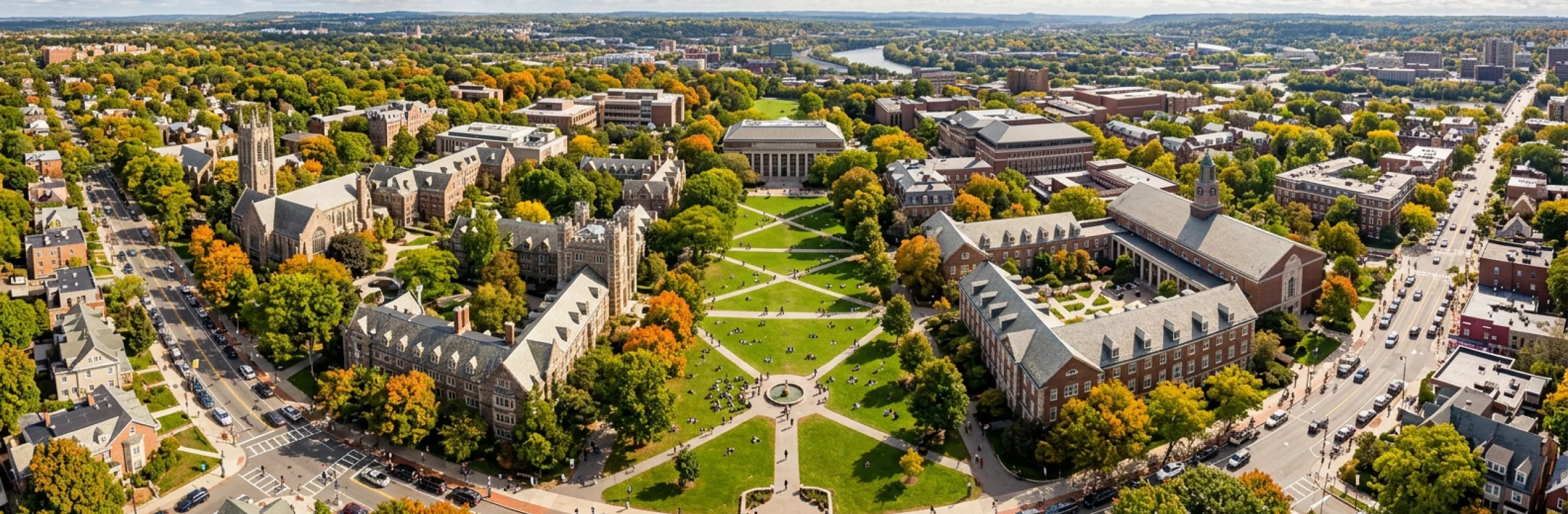 Aerial view of a green quad crossed by paths and ringed by brick buildings